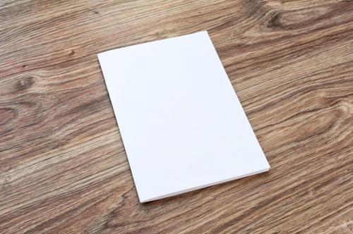Blank of brochure is on a wooden desk.